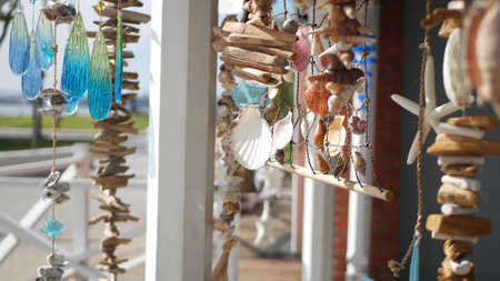 Nautical style hanging seashells decoration, beachfront blue wooden holiday home, pacific coast, California USA. Marine pastel interior decor of beach house in breeze. Summertime sea wind aesthetic.の写真素材