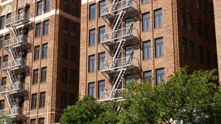 Fire escape ladder outside residential brick building in San Diego city, USA. Typical New York style...