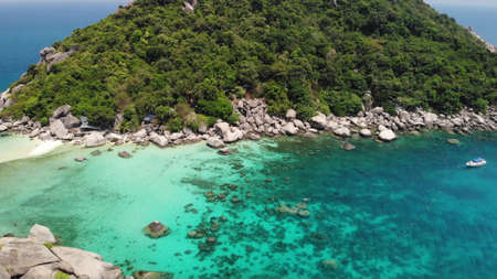 Boats near small islands. Motor dive boats floating on calm blue sea near unique small islets connected with white beaches and pier on sunny day in Thailand. Unique Nang yuan koh taoの写真素材