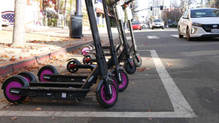 SAN DIEGO, CALIFORNIA USA - 4 JAN 2020: Row of ride sharing electric scooters parked on street in Gaslamp Quarter. Rental dockless public bikes, eco transport in city. Rent kick cycle with mobile app.のeditorial素材