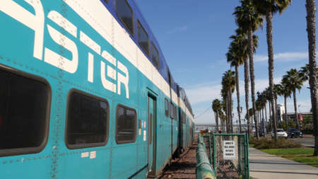 SAN DIEGO, CALIFORNIA USA - 13 FEB 2020: Coaster Commuter and palms, public rail transportation in America. Express passenger railway train, railroad nctd transport near Santa Fe station and Gaslamp.のeditorial素材