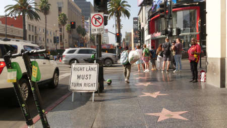 LOS ANGELES, CALIFORNIA, USA - 7 NOV 2019: Walk of fame promenade, Hollywood boulevard in LA city. Pedastrians walking on sidewalk of street. Entertainment and cinema industry iconic tourist landmark.のeditorial素材