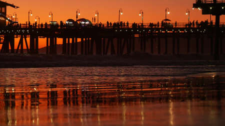 California summertime beach aesthetic, golden sunset. Vivid sky over pacific ocean waves. Santa Monica popular resort, Los Angeles CA USA. Famous pier against atmospheric moody evening sundown in LA.の写真素材