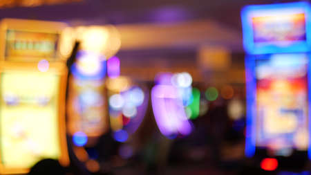 Defocused slot machines glow in casino on fabulous Las Vegas Strip, USA. Blurred gambling jackpot...