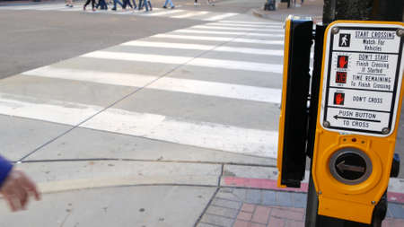 Traffic light button on pedestrian crosswalk, people have to push and wait. Traffic rules and...
