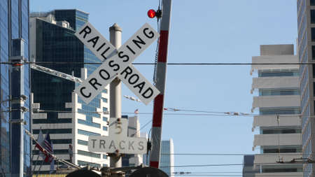 Level crossing warning signal in USA. Crossbuck notice and red traffic light on rail road...