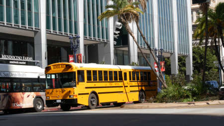 San Diego, California USA - 13 Feb 2020: American yellow school bus on street in downtown. Schoolbus...
