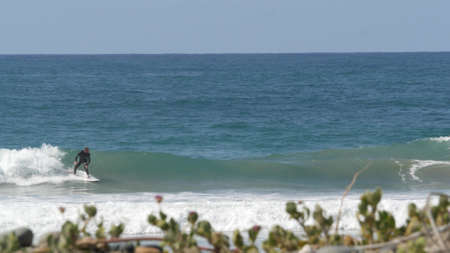Encinitas, California USA - 23 Feb 2020: Surfers in ocean, pacific coast big blue sea water waves....