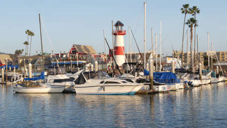 Oceanside, California USA - 27 Jan 2020: Waterfront harbor fisherman village, yachts sailboats floating, marina harbor quay. Sail boat masts, nautical vessels moored in port, lighthouse or beacon.のeditorial素材