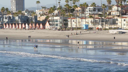 Foto de Oceanside, California USA - 11 Feb 2020: Local people walking strolling, pacific ocean coast, beach from pier. Sea water waves tide, shore sand. Beachfront vacations resort. Waterfront promenade. - Imagen libre de derechos