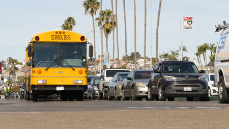 San Diego, California USA - 31 Jan 2020: American yellow school bus on street in downtown. Schoolbus shuttle on road, city near Los Angeles. Education transportation infrastructure. Low angle view.のeditorial素材