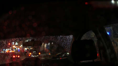 Defocused evening street, blurred bokeh. Lights of city and cars on rainy night. Reflection of...