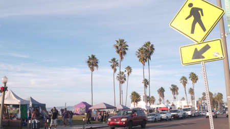 San Diego, California USA - 21 Nov 2020: Cars and people on city street of Ocean Beach by pier. Parking on sea coast. pedestrians walk on beachfront road. Palm trees on shore, waterfront boardwalk.のeditorial素材