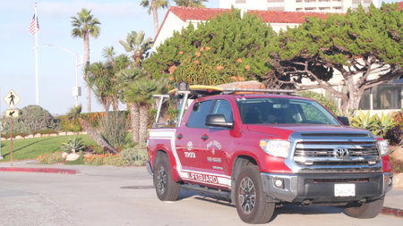 La Jolla, California USA - 23 Nov 2020: Lifeguard red pickup truck, life guard auto by beach. Rescue pick up car on coast for surfing safety, lifesavers 911 vehicle. Palm tree on San Diego city streetのeditorial素材