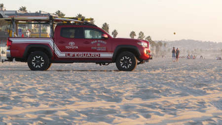 San Diego, California USA - 25 Nov 2020: Lifeguard red pickup truck, life guard auto on Mission beach. Rescue pick up car on ocean coast, surfing and public safety, lifesavers 911 vehicle and people.のeditorial素材