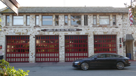 Carmel By The Sea, California USA - 10 Dec 2020: Red gates of cute fire station, city near Monterey. Fire house or firemens hall architecture. American flag on building for firefighters. Public safetyのeditorial素材