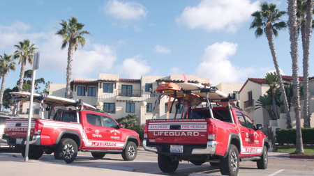 La Jolla, California USA - 23 Nov 2020: Lifeguard red pickup truck, life guard auto by beach. Rescue pick up car on coast for surfing safety, lifesavers 911 vehicle. Palm tree on San Diego city streetのeditorial素材