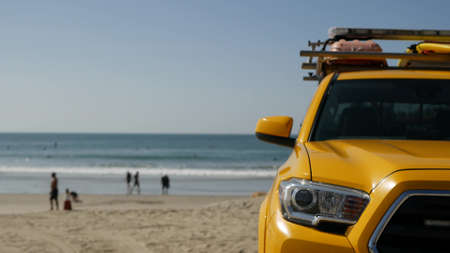 Yellow lifeguard car, Oceanside beach, California USA. Coastline rescue life guard pick up truck, lifesavers vehicle. Iconic auto and ocean coast. Los Angeles vibes, summertime aesthetic atmosphere.の写真素材