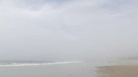 Sandy misty beach, Encinitas California USA. Pacific ocean coast, dense fog brume, empty sea shore....
