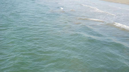 Pacific ocean big waves splashing, California coast USA. Water surface texture and sea foam. Seascape near beach, tide of blue water. Frome above, top down high angle view. Sunny tropical summer day.の写真素材