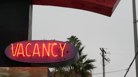 Red neon sign Vacancy glowing, motel or hotel on road in California USA. Illuminated text about lodging during road trip. Tourism or traveling in America.の写真素材