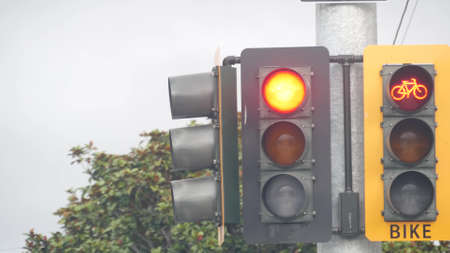 Yellow traffic light or stoplight signal for bicyclists on crossroad, California USA. Bike lane on...