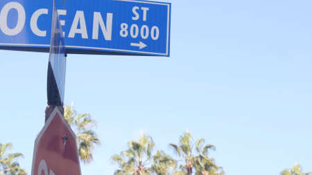 Ocean street road sign on crossroad, California city, USA. Waterfront tourist resort near Los Angeles, beachfront travel destination for waterside summer vacations. Coastal palm trees in La Jolla.の写真素材