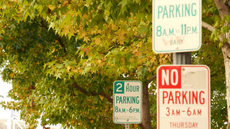 Green parking and red no parking road sign on city street in California, USA. American traffic signage or roadsign on roadside. Transportation rules in United States.の写真素材