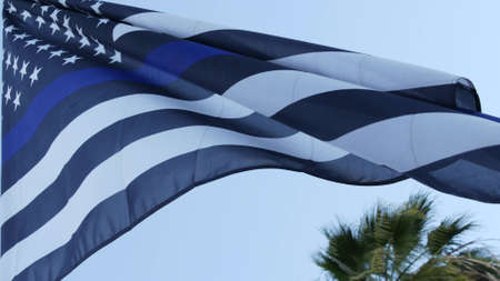 Black white american monochrome flag with blue stripe or line, police support. Solid star-spangled banner waving in wind breeze.の写真素材