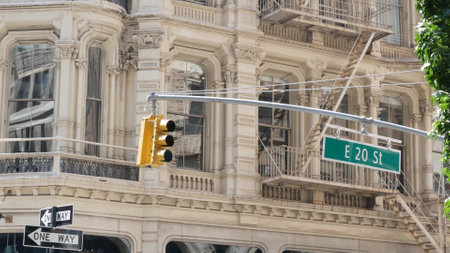 New York City street crossroad, yellow traffic light, transport road intersection, United States. Broadway classic building architecture. NYC Manhattan midtown. One way arrow road sign. Fire ladder.の写真素材