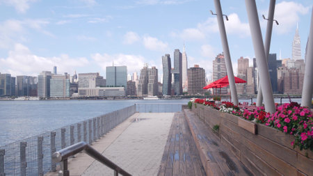 New York City waterfront skyline, Manhattan Midtown buildings, riverfront skyscrapers by East river water. Waterside cityscape view, Hunters Point pier columns, Long Island, Queens. United States.の写真素材