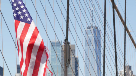 Flag on Brooklyn Bridge, Manhattan downtown, New York City skyline, financial district cityscape....