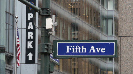 Fifth avenue, 5 ave road sign, Manhattan midtown architecture, New York City 5th av street corner. Traffic crossroad signage, USA. Parking garage and american flag.の写真素材