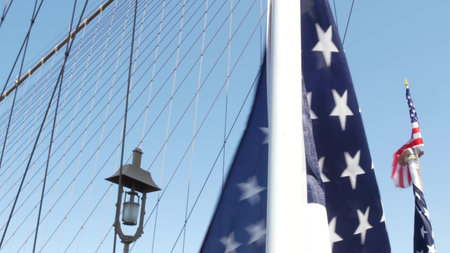 American flag on Brooklyn Bridge to Manhattan, New York City. Patriotic symbol of liberty, freedom,...