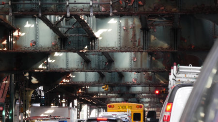 Elevated subway above New York City street. Metropolitan bridge over road Queens. Overhead metro...