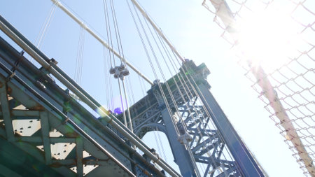 Manhattan Bridge to Brooklyn Dumbo. New York City symbol, USA travel destination. Architecture of United States, tourist landmark. Cable-stayed bridge. Cables and sky from pedestrian path. Sun rays.の写真素材