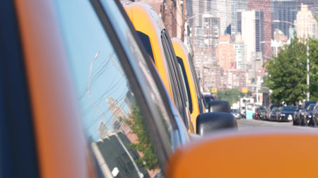 New York City. Row of yellow Taxi cars on street, Queens. Many taxi cabs on avenue, Long Island, LIC. Medallion taxicab and Manhattan Midtown urban skyline cityscape. High-rise building architecture.の写真素材