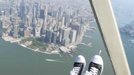 New York City doors off helicopter flight, heli flying over Manhattan Downtown, United States. World Trade Center. Feet in sneakers, tourist legs, shoes selfie pov. Extreme travel USA.の写真素材