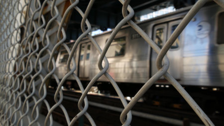 New York City Manhattan Bridge to Brooklyn Dumbo. Subway metro train from pedestrian path. United States public railway transport. Railroad traffic and architecture in USA.の写真素材