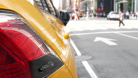 New York City. Yellow taxi car on Manhattan street. Taxi cab on Midtown Lexington avenue. Medallion taxicab rear view on Lex ave waiting for people or passengers on road. Urban scene in United States.の写真素材