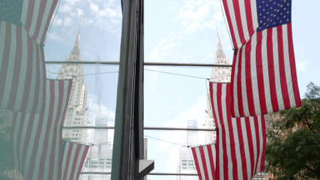 New York, american flag waving. Chrysler building. Manhattan midtown 42 street, city architecture. Symbol of freedom, democracy, liberty and patriotism. Star-Spangled Banner, Old Glory. Stars, Stripesの写真素材