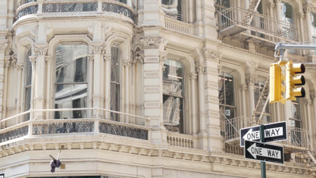 New York City street crossroad, yellow traffic light, transport road intersection, United States. Broadway classic building architecture. NYC Manhattan midtown. One way arrow road sign. Fire ladder.の写真素材