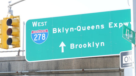 Brooklyn Queens expressway road sign, New York City highway signage, green traffic roadsign shield, United States transportation. One way arrow, yellow traffic light.の写真素材