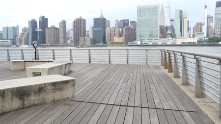 New York City waterfront skyline, Manhattan Midtown buildings, riverfront skyscrapers by East river water. Waterside cityscape, Gantry Plaza Park, Long Island, Queens, United States. Riverside bench.のeditorial素材