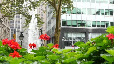 New York City Lower Manhattan, Downtown Financial District architecture, United States. High-rise buildings on Broadway street, USA. American urban scene, fountain in Bowling Green Park, NYC. Flowers.の写真素材