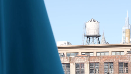 New York City classic industrial building exterior architecture, USA. Typical red brick, windows on facade. Rooftop water tower, tank on roof in Queens, United States. Chrysler building top spire.のeditorial素材