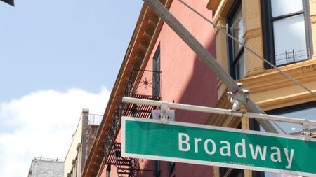 Broadway street road sign, Manhattan midtown property, house architecture, New York City real estate. Green roadsign on crossroad. Historic district intersection, United States.の写真素材
