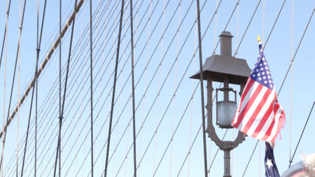 American flag on Brooklyn Bridge to Manhattan, New York City. Patriotic symbol of liberty, freedom, democracy and independence, bridge cables. United States star-spangled banner in wind. Travel USA.の写真素材