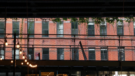 New York City classic building architecture. Urban residential house exterior. Real estate property in USA. Typical red brick facade. High line end in Chelsea, Meatpacking district. Light bulb garlandの写真素材