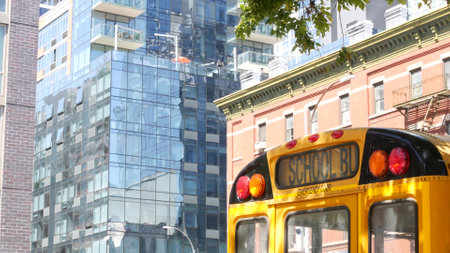 Yellow School Bus on New York Manhattan street, schoolbus truck on city road. Children education and transportation, USA. American school shuttle, 10 avenue Chelsea red brick house, United States.の写真素材